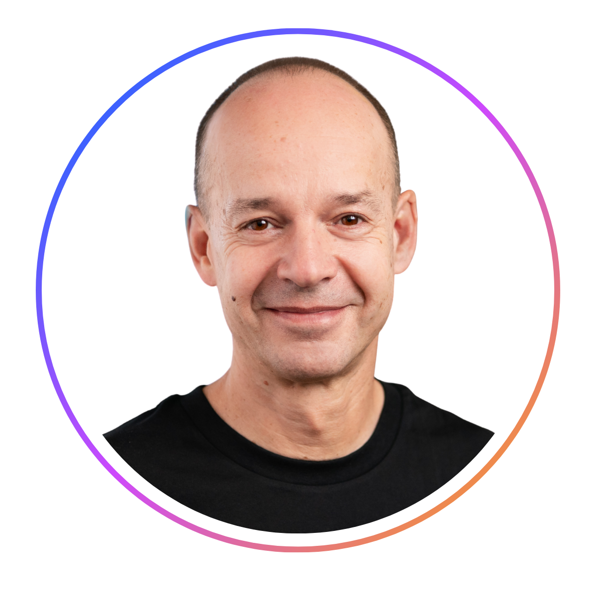 Smiling person with a shaved head wearing a black shirt, framed in a circular border with a gradient color.